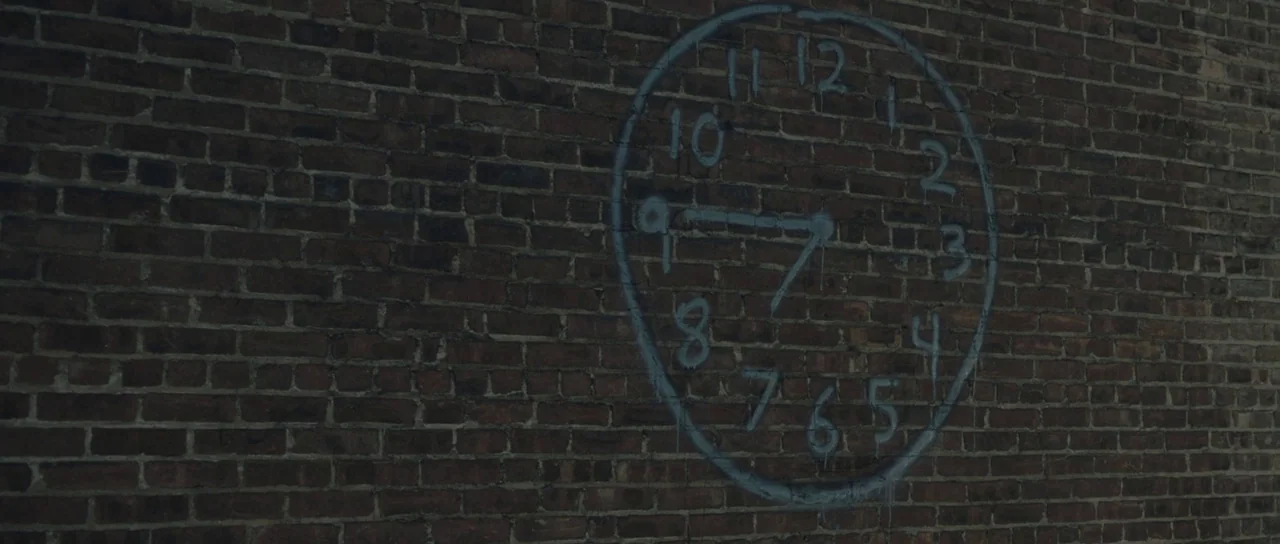 Synecdoche, New York (2008) movie still: A solitary, hand-drawn clock in faded blue paint adorns a dark, weathered brick wall, serving as a silent,…