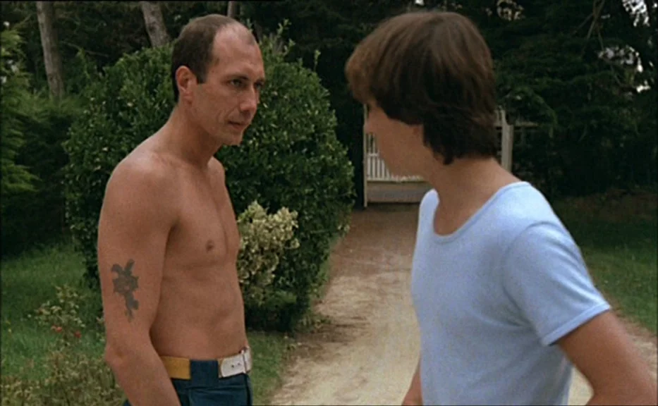 Pauline At the Beach (Pauline à la plage) (1983) movie still: medium — A residential driveway lined with manicured bushes and trees provides the…