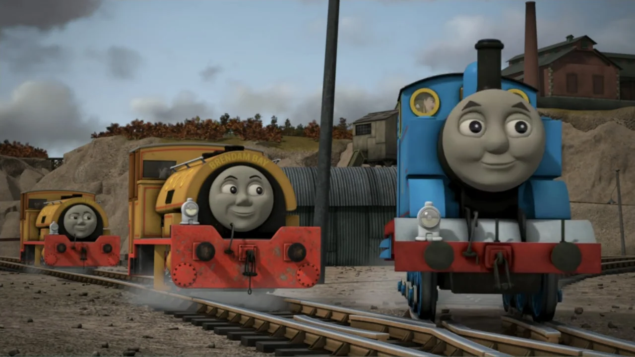 Thomas & Friends: Tale of the Brave (2014) movie still: wide — A sunny railway yard featuring three distinct train engines on parallel metal tracks.…