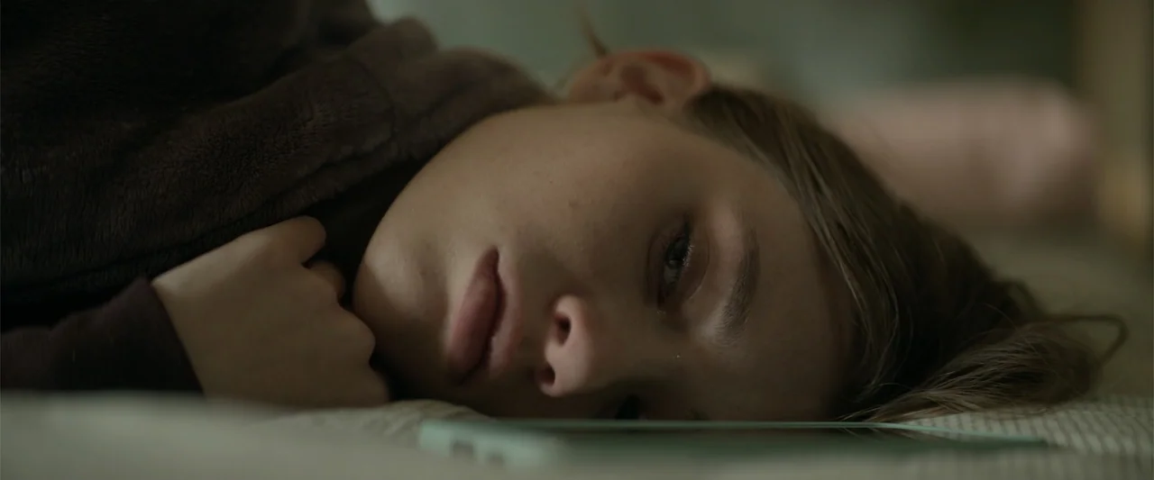 Marked Men: Rule + Shaw (2025) movie still: closeup — A bedroom interior features a person lying on a bed with soft bedding. The subject is resting…
