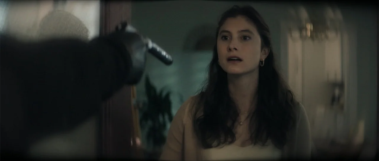 Crescent City (2024) movie still: medium — An interior residential space features walls with soft, muted coloring and a visible plant. A woman…