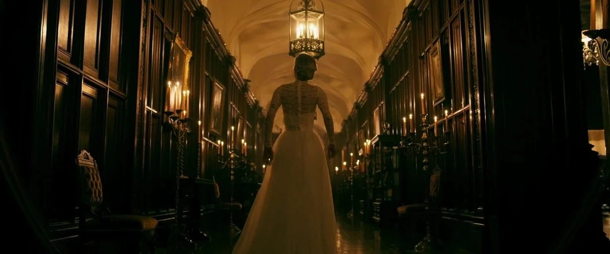 Ready or Not (2019) movie still: fullbody — A long, dark hallway in a mansion features wood-paneled walls and arched ceilings. A woman in a white…