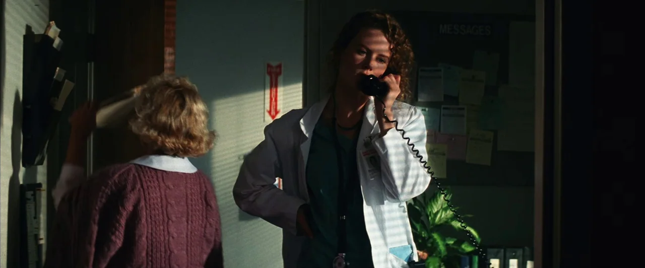 Days of Thunder (1990) movie still: medium — A hospital workspace features a bulletin board with messages and a window with blinds. A nurse speaks…
