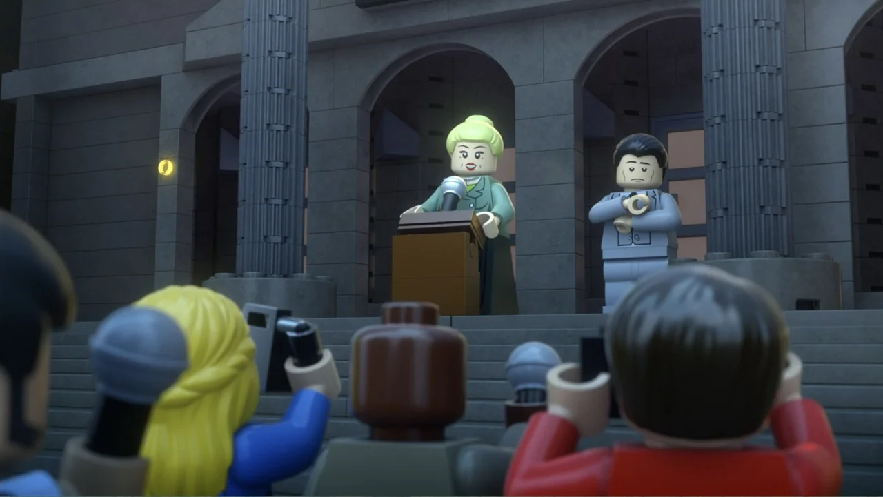 LEGO DC Batman: Family Matters (2019) movie still: medium — A stone building entrance serves as the backdrop for an outdoor press conference…