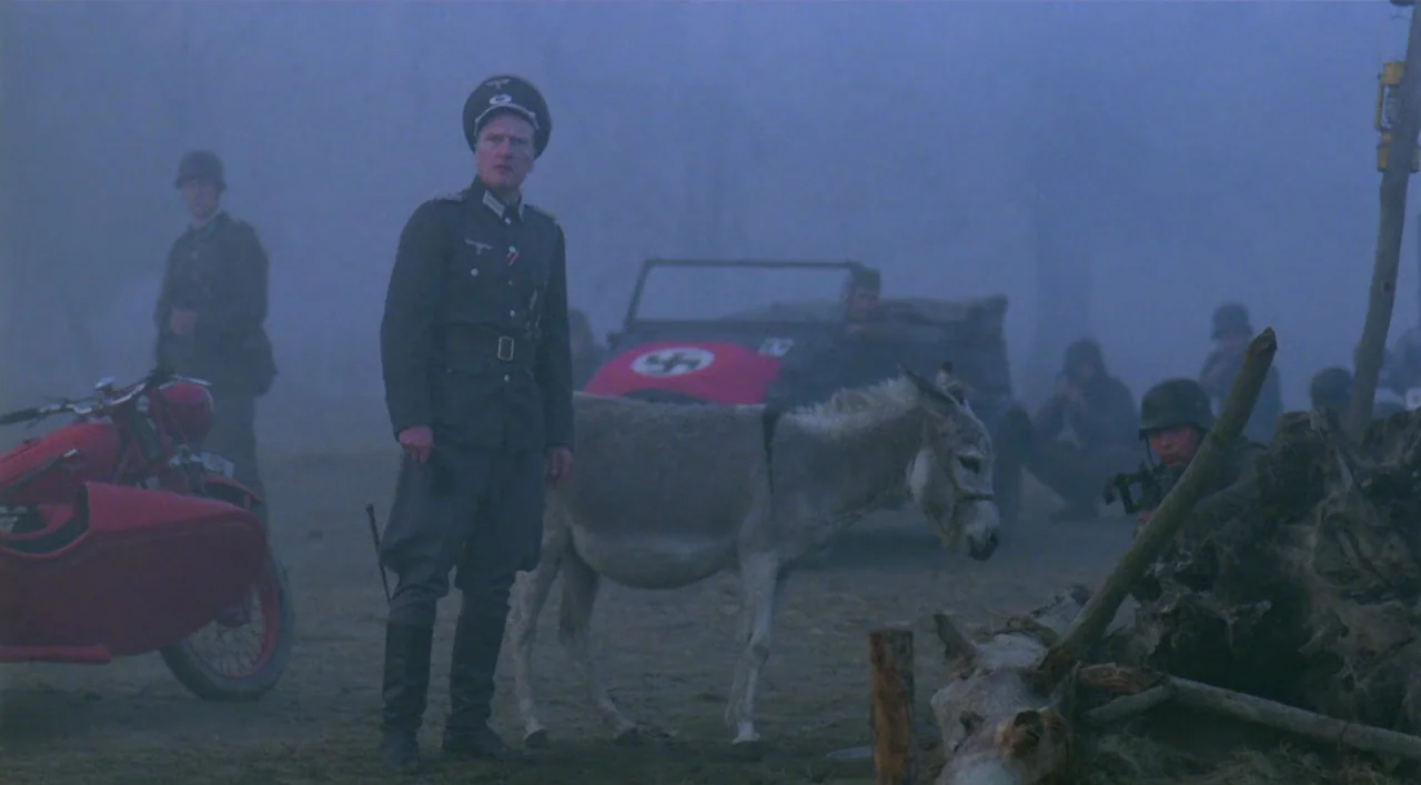 Underground (1995) movie still: fullbody — A field covered in heavy fog with German soldiers and a vehicle in background. An officer in a grey…