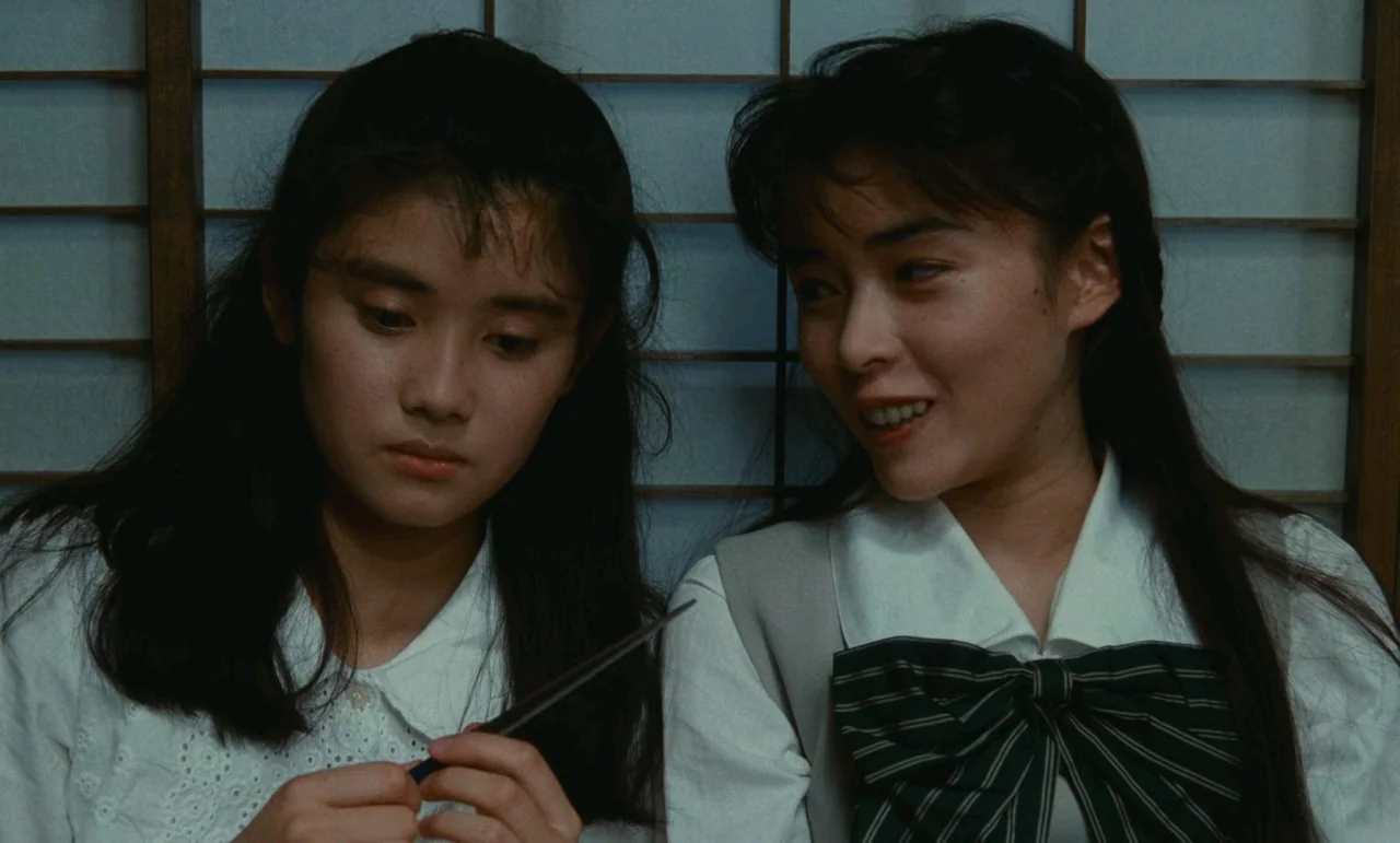 Chizuko’s Younger Sister (1991) movie still: medium — A Japanese room features a shoji paper screen partition against the wall. Two young women sit…