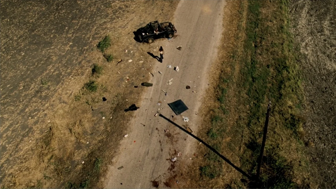 The Texas Chainsaw Massacre: The Beginning (2006) movie still: wide — An isolated dirt road runs through dry agricultural fields with debris…