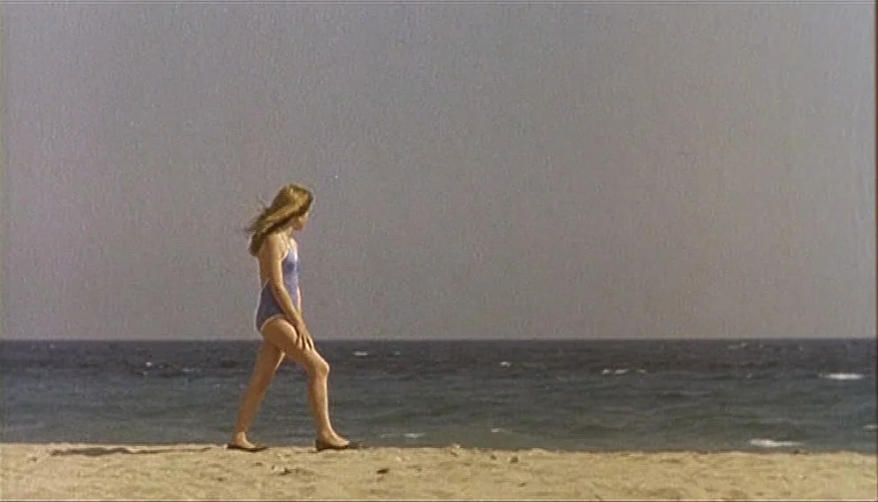 Labyrinth of Passion (1982) movie still: fullbody — A sandy beach stretches horizontally across the lower frame with the ocean beyond. A teenage…