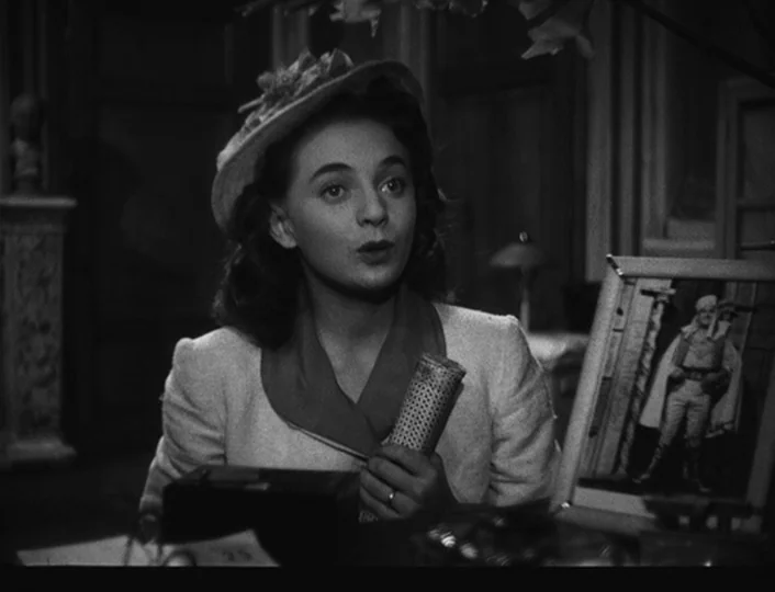 The White Sheik (1952) movie still: medium — A classic 1940s interior space featuring furniture and decorative items in the background. A woman…