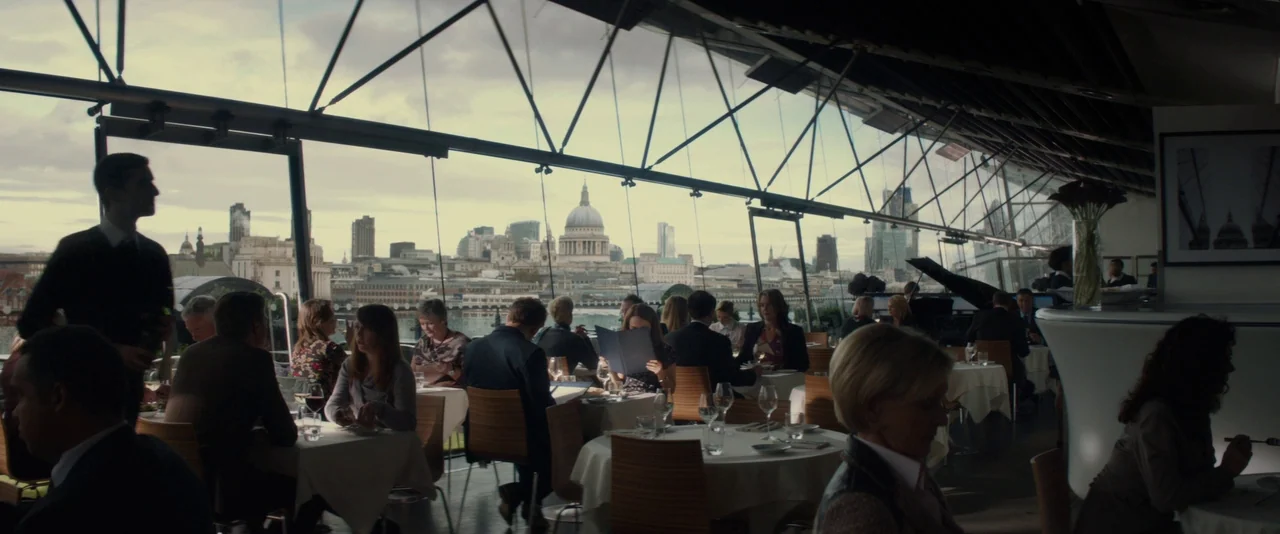Thor: The Dark World (2013) movie still: wide — A high-end restaurant features expansive glass walls overlooking a sprawling city skyline. Numerous…