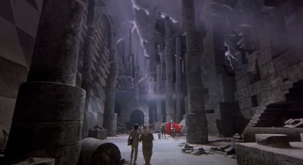 Time Bandits (1981) movie still: wide — A vast, ruined stone hall features towering, fragmented columns and a checkered wall pattern. Two small…