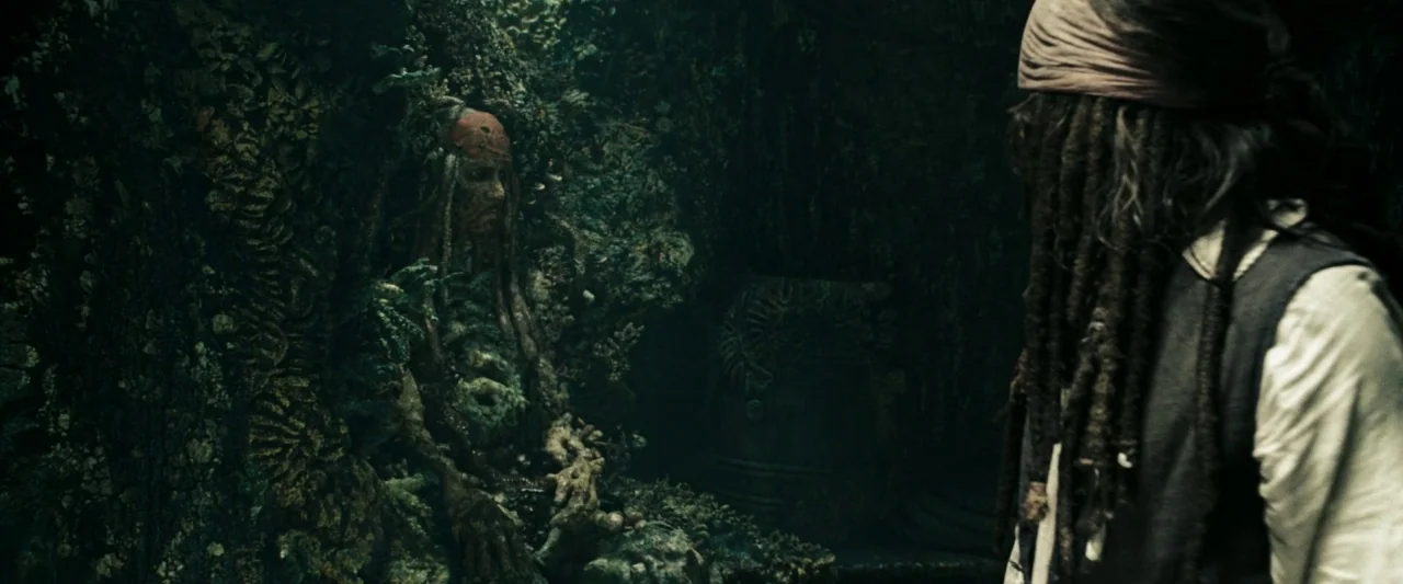 Pirates of the Caribbean: At World’s End movie still: medium — A dark cavern wall is covered in thick moss and calcified organic material. A man…
