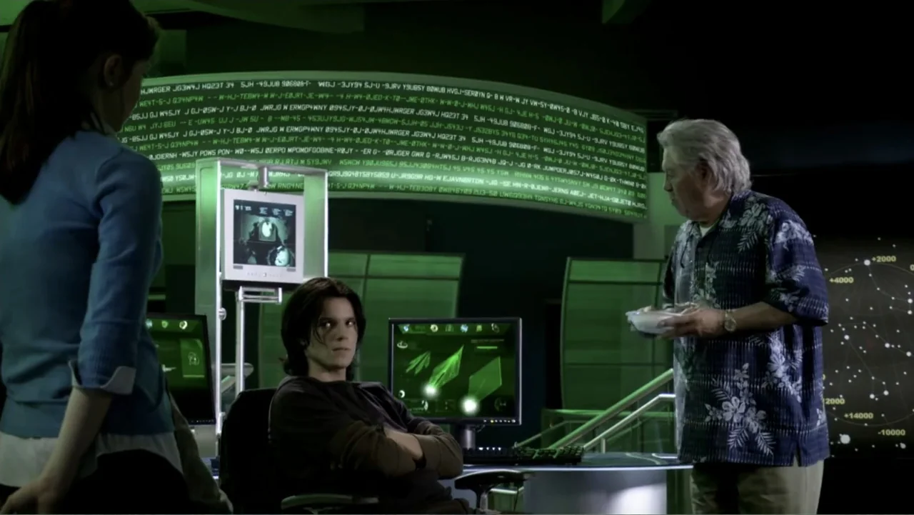 Ben 10: Race Against Time (2008) movie still: medium — A high-tech darkened room features large glowing green digital data streams on curved…