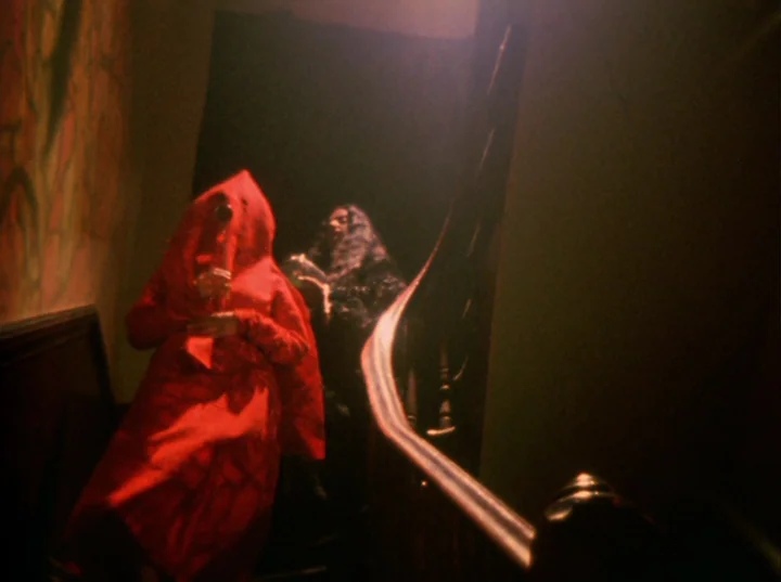 Invocation of My Demon Brother (1969) movie still: fullbody — A dark, wood-paneled staircase with a polished banister descends into shadow. Two…