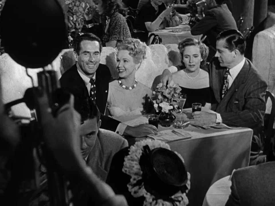 The Best Years of Our Lives (1946) movie still: medium — A crowded restaurant with groups seated at tables under bright, vintage lighting. Four…