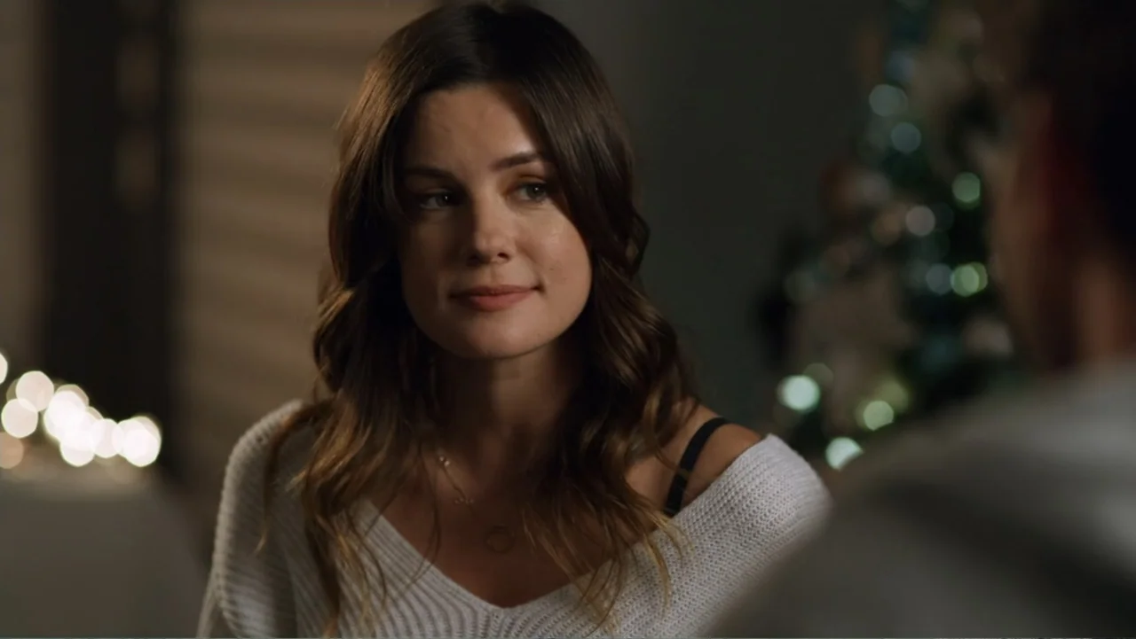 Always and Forever Christmas (2019) movie still: medium — A blurred indoor setting featuring soft out-of-focus string lights in the background. A…