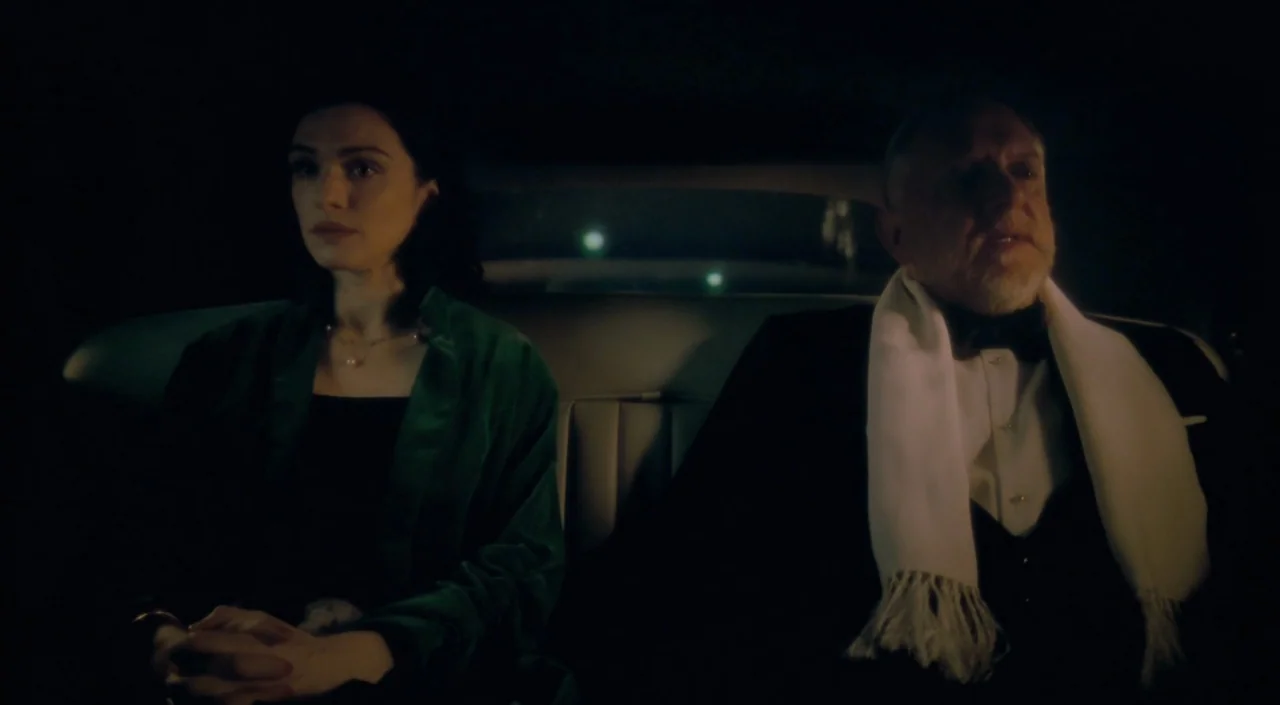 The Deep Blue Sea (2011) movie still: medium — The interior of a dimly lit vintage car at night. A woman in green and an older man in a tuxedo sit…