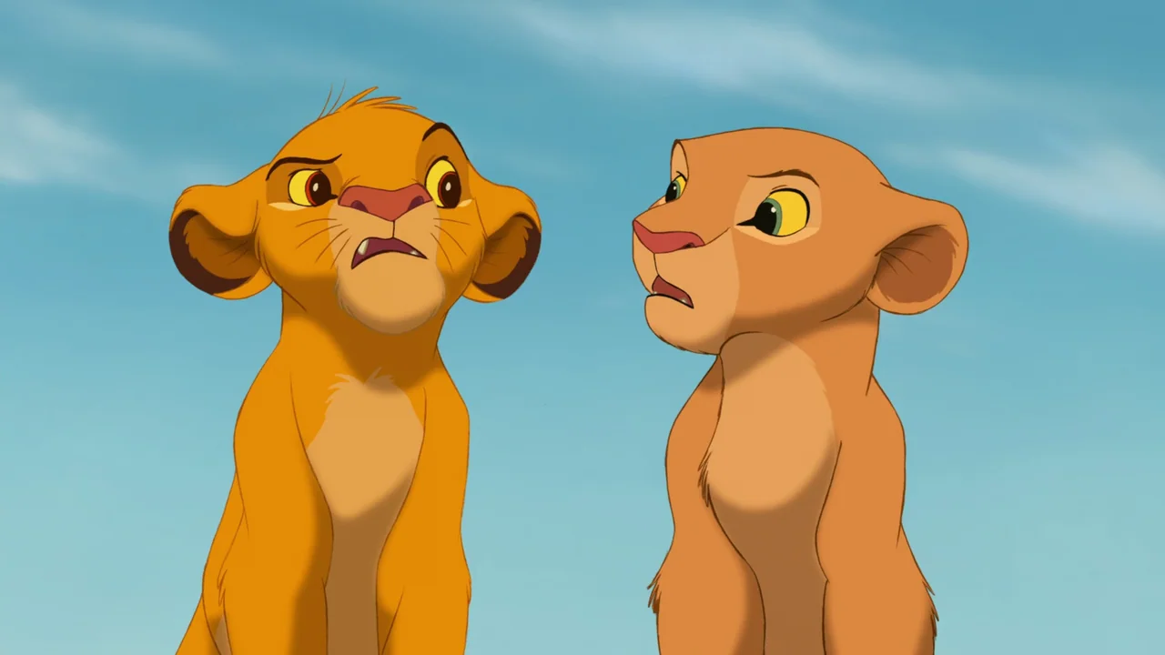 The Lion King (1994) movie still: medium — Two animated lion cubs stand together against a solid blue sky background. The characters appear to be…