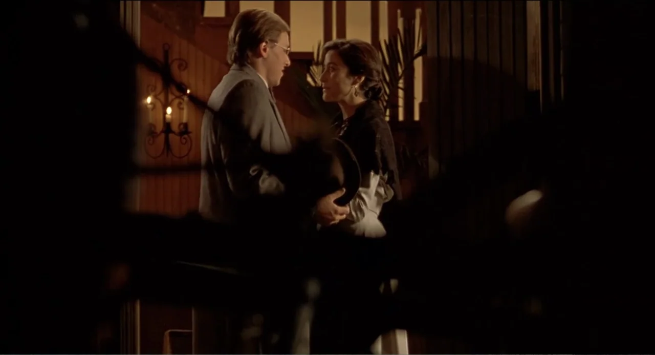 Like Water for Chocolate (1992) movie still: medium — A dimly lit indoor doorway features a man and woman in period clothing standing together. The…