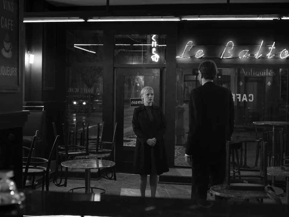 Cold War (2018) movie still: medium — A quiet cafe at night with tables cleared and chairs stacked on them. A woman stands facing a man near the…