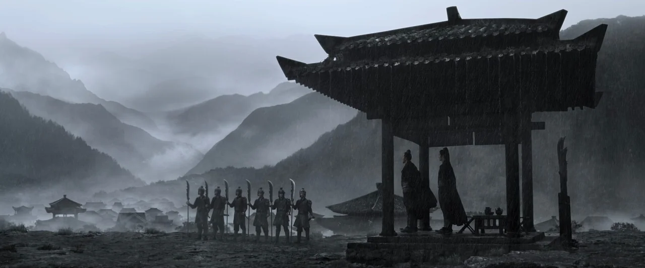 Shadow (2018) movie still: wide — A stone pavilion sits on a ridge during a heavy rainstorm with misty mountains. A row of soldiers in traditional…