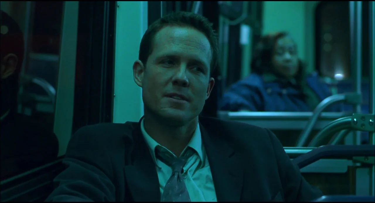 Hellraiser: Hellseeker (2002) movie still: medium — An interior of a city bus at night bathed in harsh green light. A man in a suit sits in the…