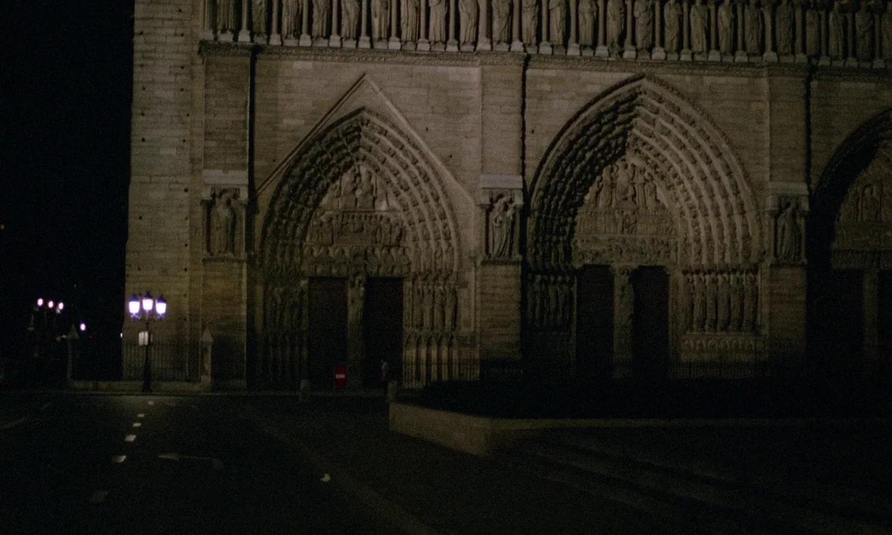 The Margin (1976) movie still: establishing — The intricate stone facade of a Gothic cathedral features deep carved archways and sculptures. A…