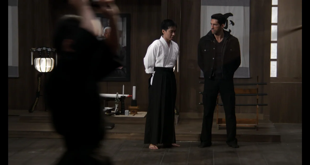 Ninja: Shadow of a Tear (2013) movie still: fullbody — A traditional wooden interior featuring a scroll on the wall and a paper lantern. Two men in…