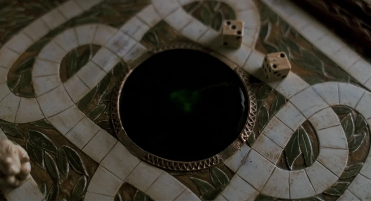 Jumanji (1995) movie still: closeup — A close-up view of an aged wooden board game with an empty circular center. Two small six-sided dice sit on…
