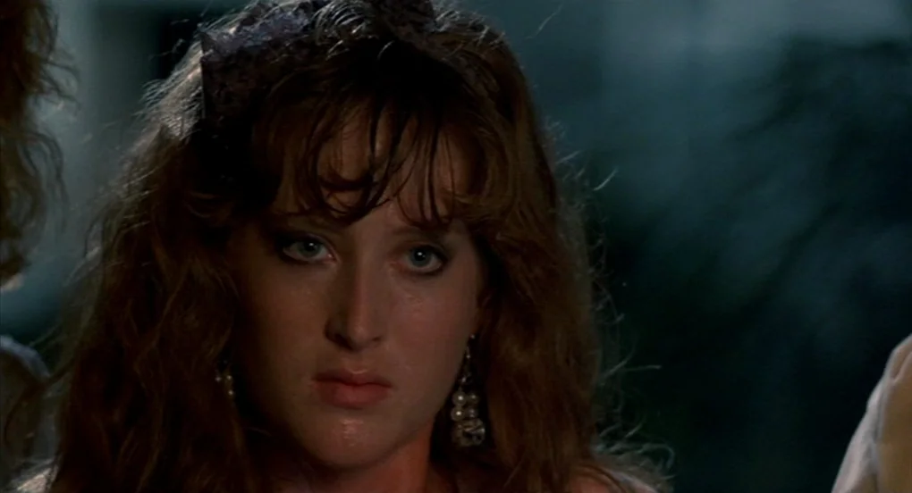 A Nightmare On Elm Street 2: Freddy’s Revenge (1985) movie still: closeup — A close-up shot of a young woman against a dark, indistinct background.…
