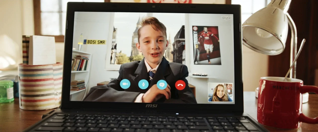 Mia and the White Lion (2018) movie still: medium — A close-up view of a laptop displaying a Skype video call with a young boy. The physical desk…
