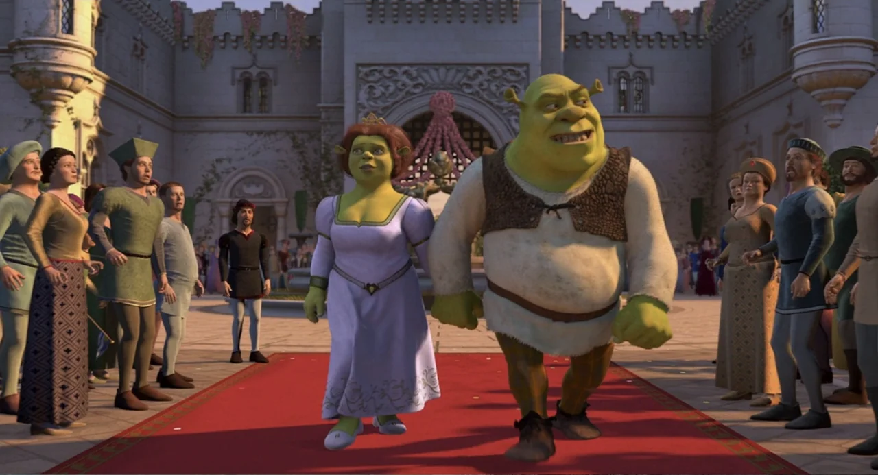 Shrek 2 (2004) movie still: fullbody — A stone courtyard features a red carpet leading toward a large arched gate. A male ogre and a woman in a…