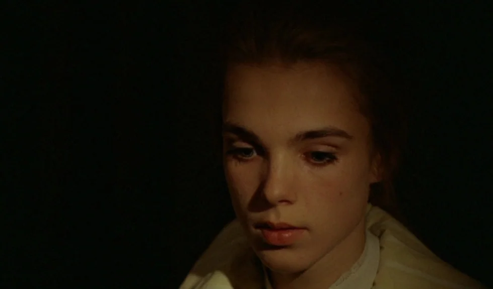 Elvira Madigan (1967) movie still: closeup — A figure is partially visible against a dark, featureless background. The subject is angled towards the…