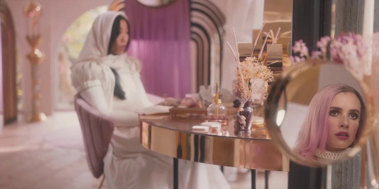 Paradise Hills (2019) movie still: medium — A pastel-colored room features a metallic dressing table with dried floral arrangements. One woman sits…