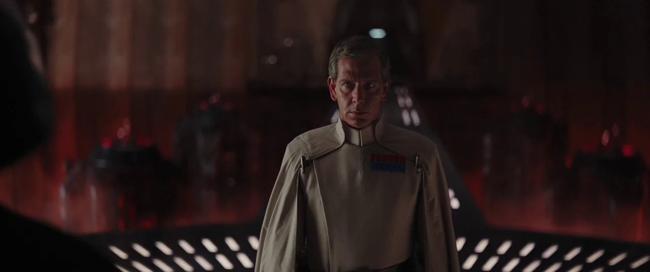 Rogue One: A Star Wars Story (2016) movie still: medium — A dark, expansive chamber features a metallic floor with recessed geometric light panels.…