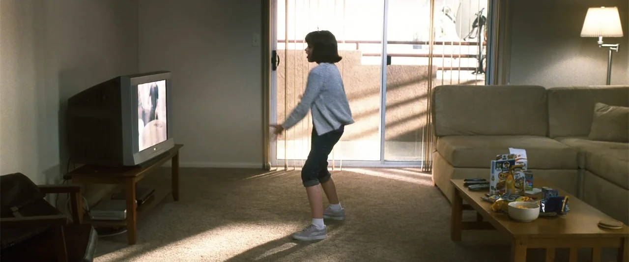 Crazy, Stupid, Love. (2011) movie still: fullbody — A carpeted living room features a beige sofa, a coffee table with snacks, and a television set.…