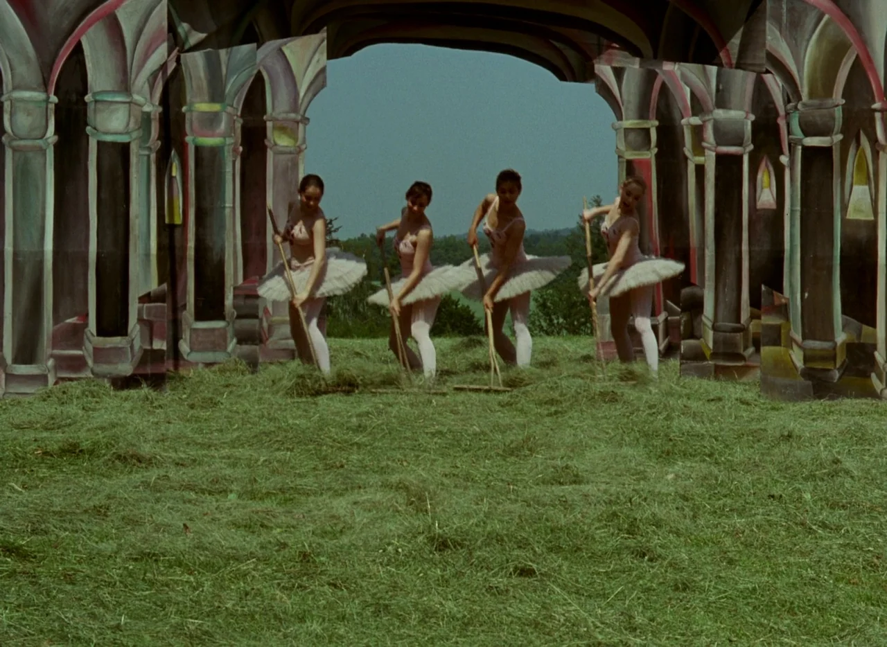 Faust (1994) movie still: fullbody — Four ballet dancers perform in a field framed by painted architectural stage set panels. The women use wooden…