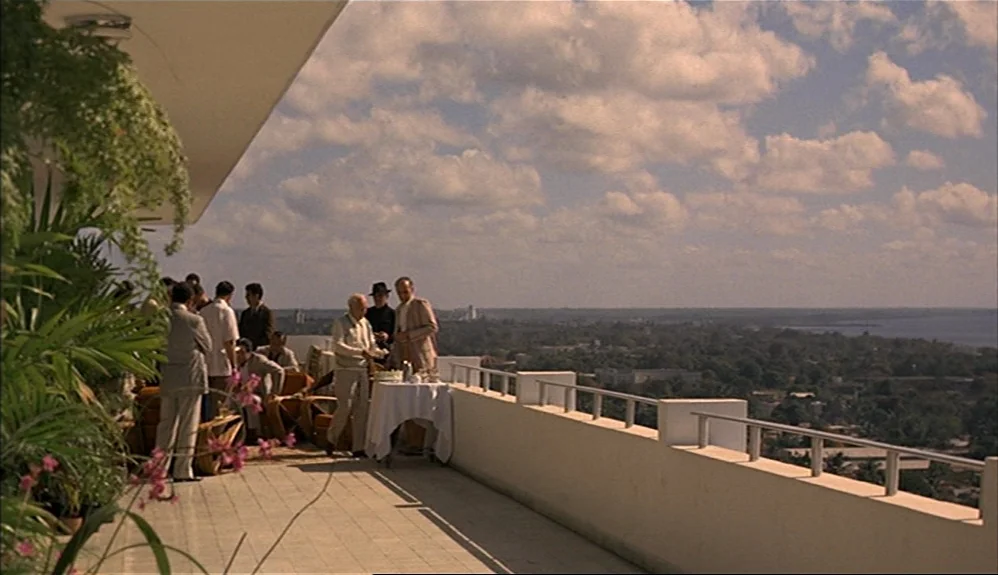 The Godfather Part II (1974) movie still: wide — An elevated terrace with tiled floors features a white railing overlooking a distant horizon. A…