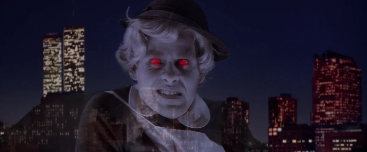 Ghostbusters 2 (1989) movie still: closeup — A translucent figure floats over a panoramic view of New York City at night. The man in a hat displays…