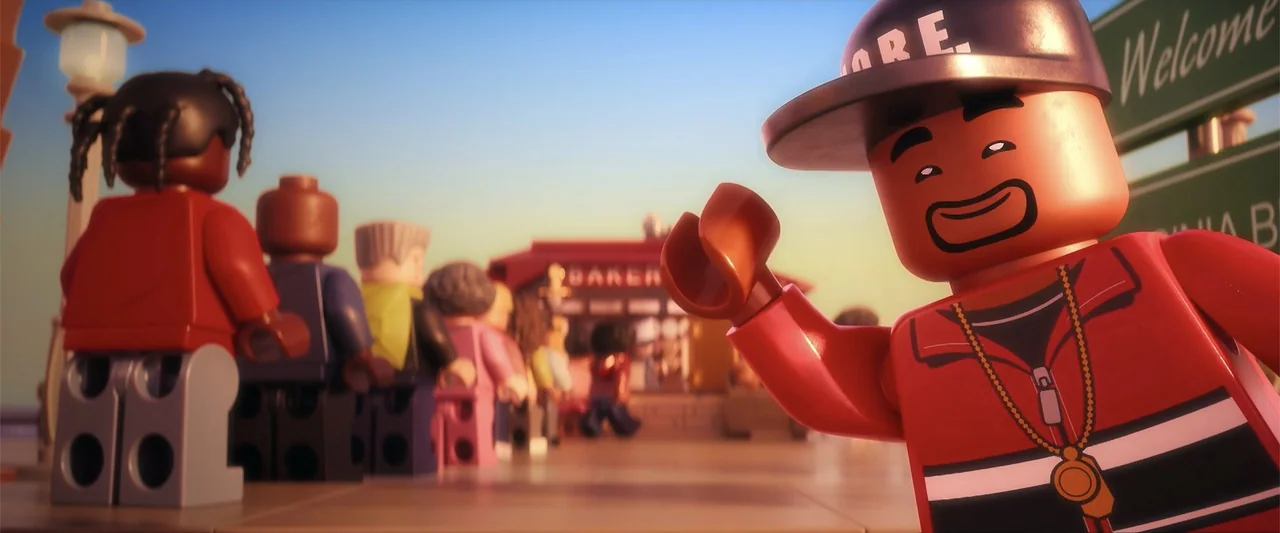 Piece by Piece (2024) movie still: medium — An outdoor sidewalk area with a line of various plastic figures stretching toward a building. The…