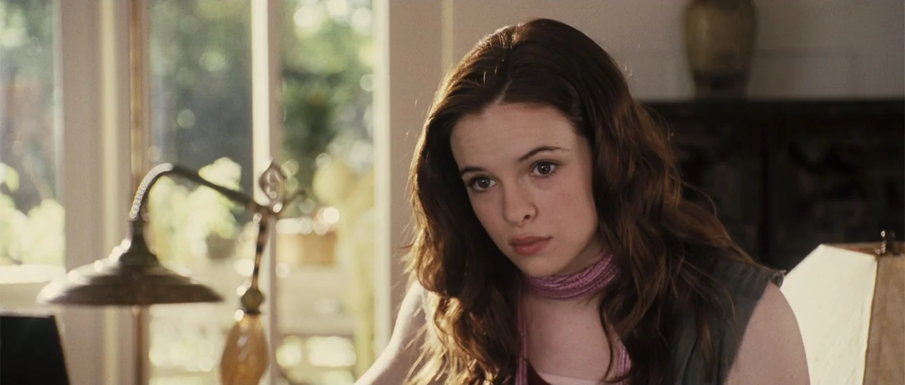 Yours, Mine & Ours (2005) movie still: closeup — A domestic interior with a bright window background and a wooden table lamp foreground. A teenage…