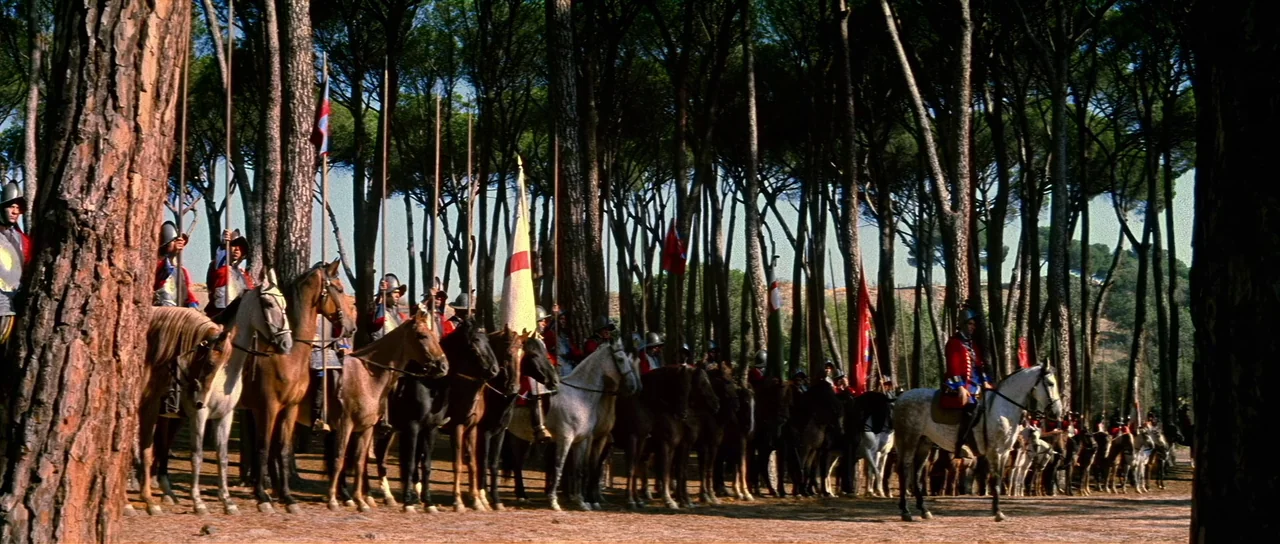 Night of the Blood Monster (1970) movie still: wide — A line of soldiers on horseback waits within a dense pine forest during the day. The men wear…