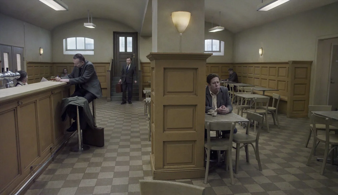 A Pigeon Sat on a Branch Reflecting on Existence (2014) movie still: wide — A spacious room features a tiled floor, wooden wainscoting, and a…