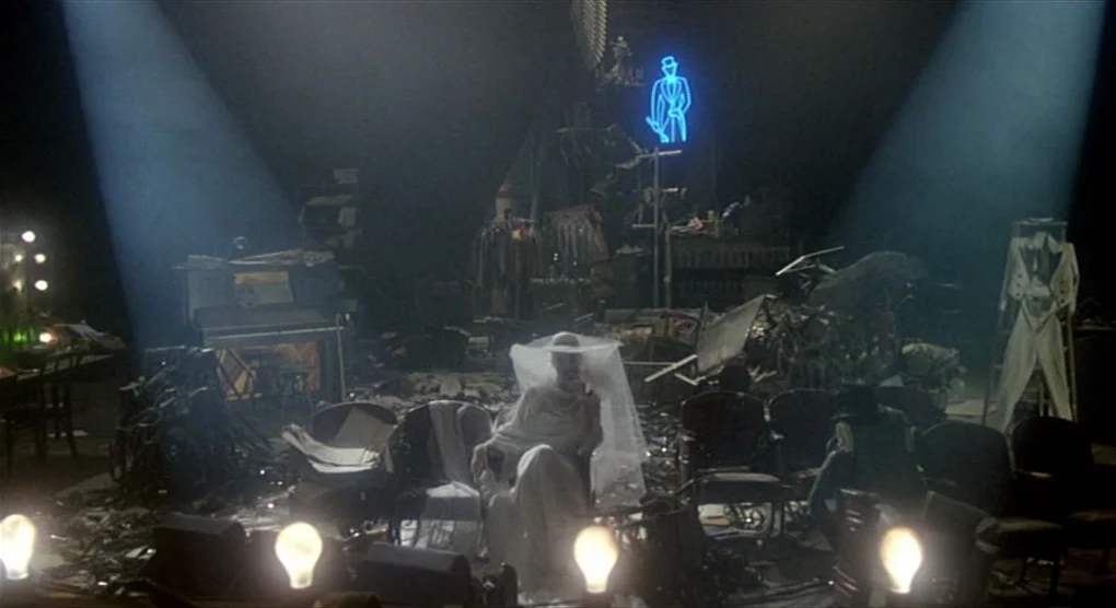 All That Jazz (1979) movie still: wide — A cluttered, dark interior of a theater filled with vintage props and costumes. A woman in a bridal gown…