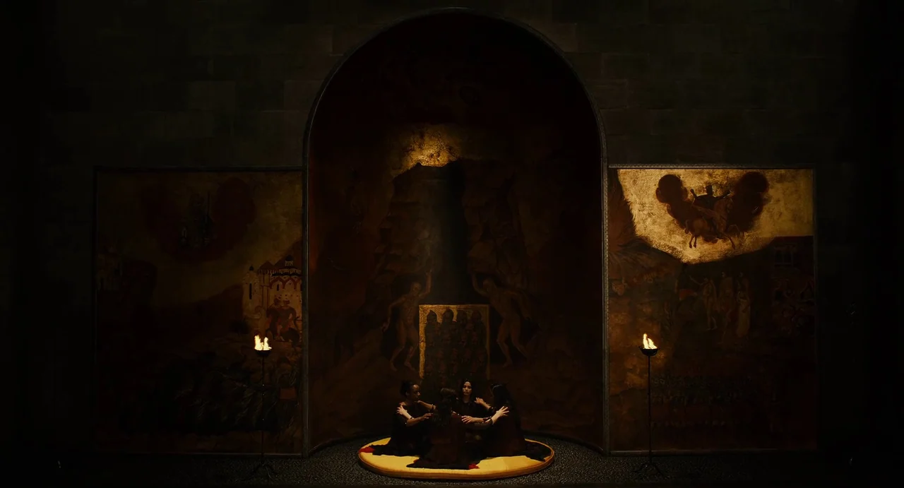 The Immortals (2011) movie still: wide — A stone-walled interior room features a central arched alcove with large, dark, gold-toned paintings. Four…