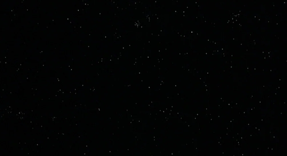 Near Dark (1987) movie still: establishing — A dense field of bright white stars scattered across a deep black void. No planetary bodies or…