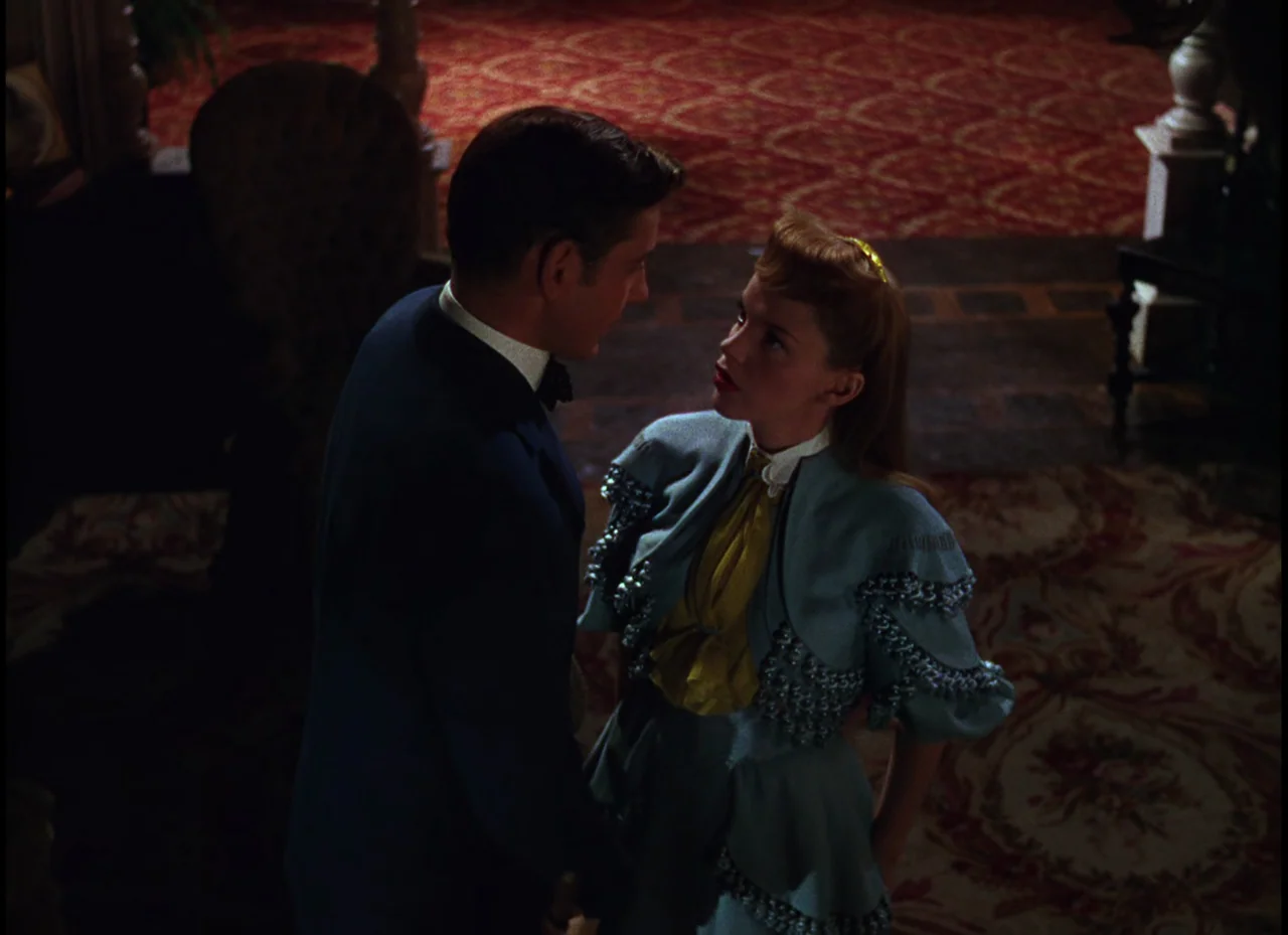 Meet Me In St. Louis (1944) movie still: medium — An ornate interior with patterned carpet and dark wooden furniture in the background. A man in a…