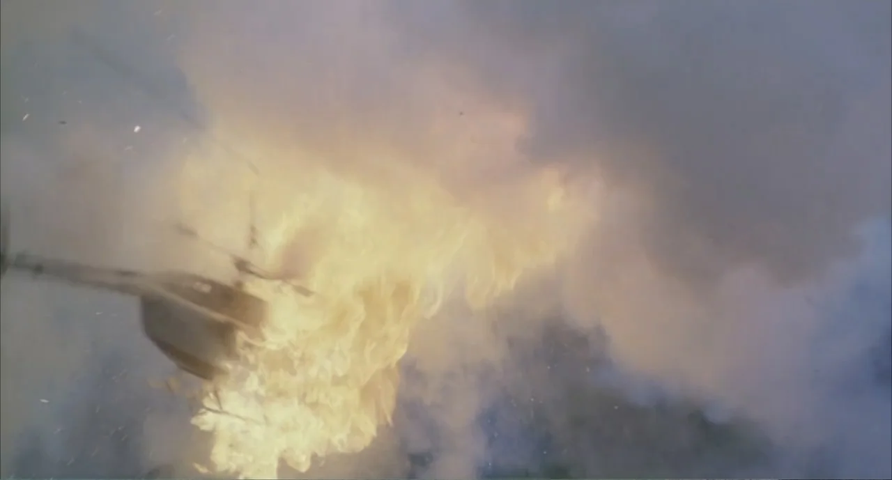 American Ninja 4: The Annihilation (1990) movie still: wide — A helicopter is engulfed in a massive fireball and thick grey smoke in the sky. The…