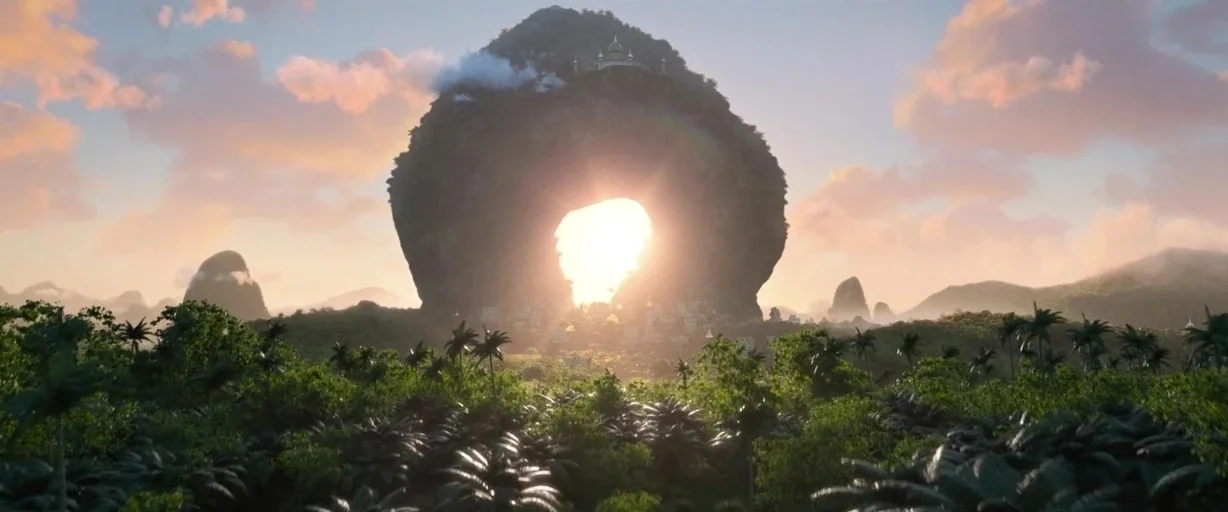 Raya and the Last Dragon (2021) movie still: establishing — A massive mountain featuring a large circular natural tunnel sits amidst a tropical…