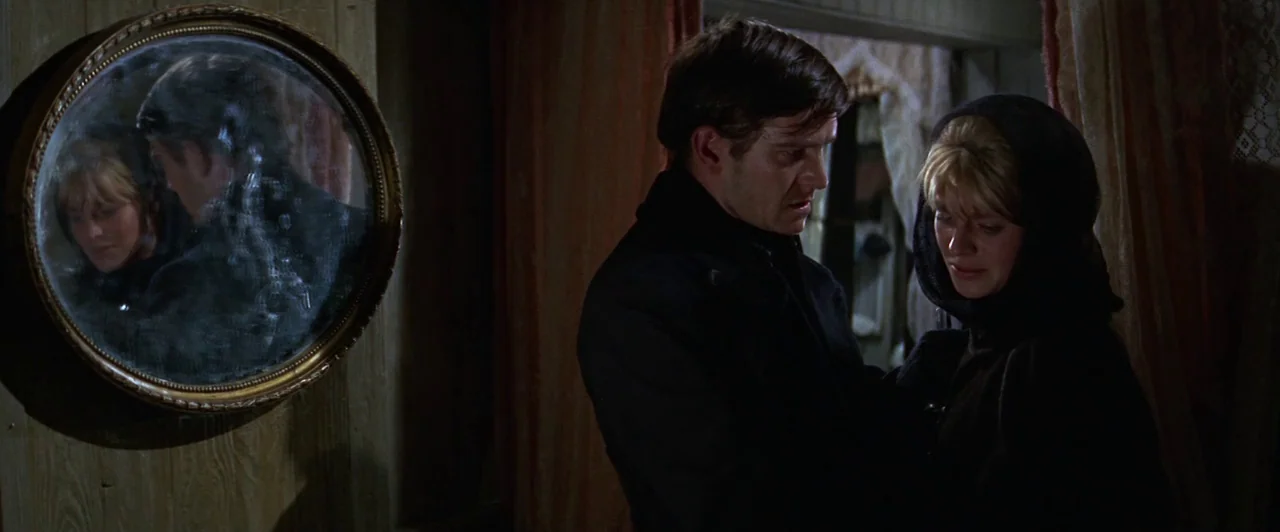 Doctor Zhivago (1965) movie still: medium — An interior space with paneled wooden walls and a decorative round wall mirror. A man stands beside a…